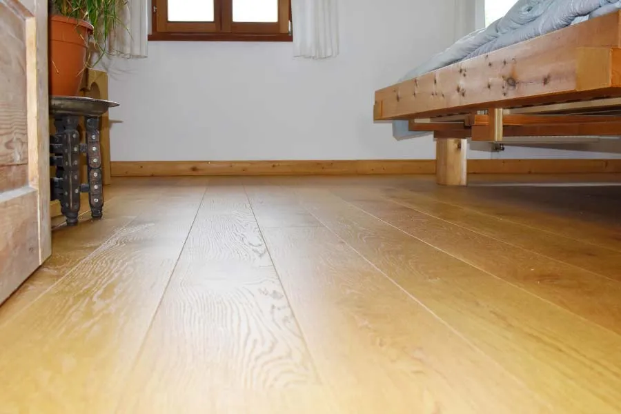 Bodennahe Aufnahme eines Holzfußbodens in einem Schlafzimmer